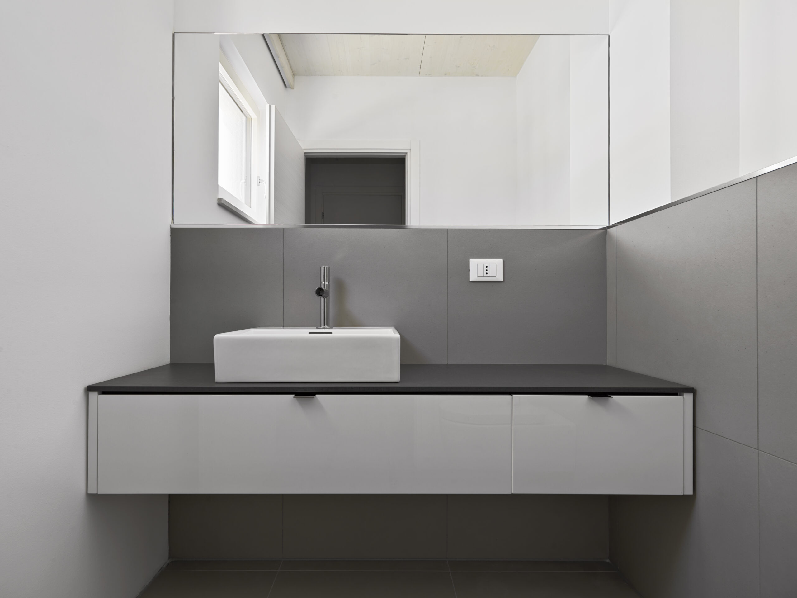 Interior of the modern bathroom in the foreground the sink cabinet and the mirror